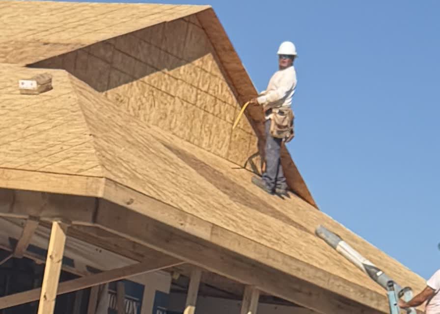 A construction worker installing roof sheathing on Shawna's new Valley Station home.