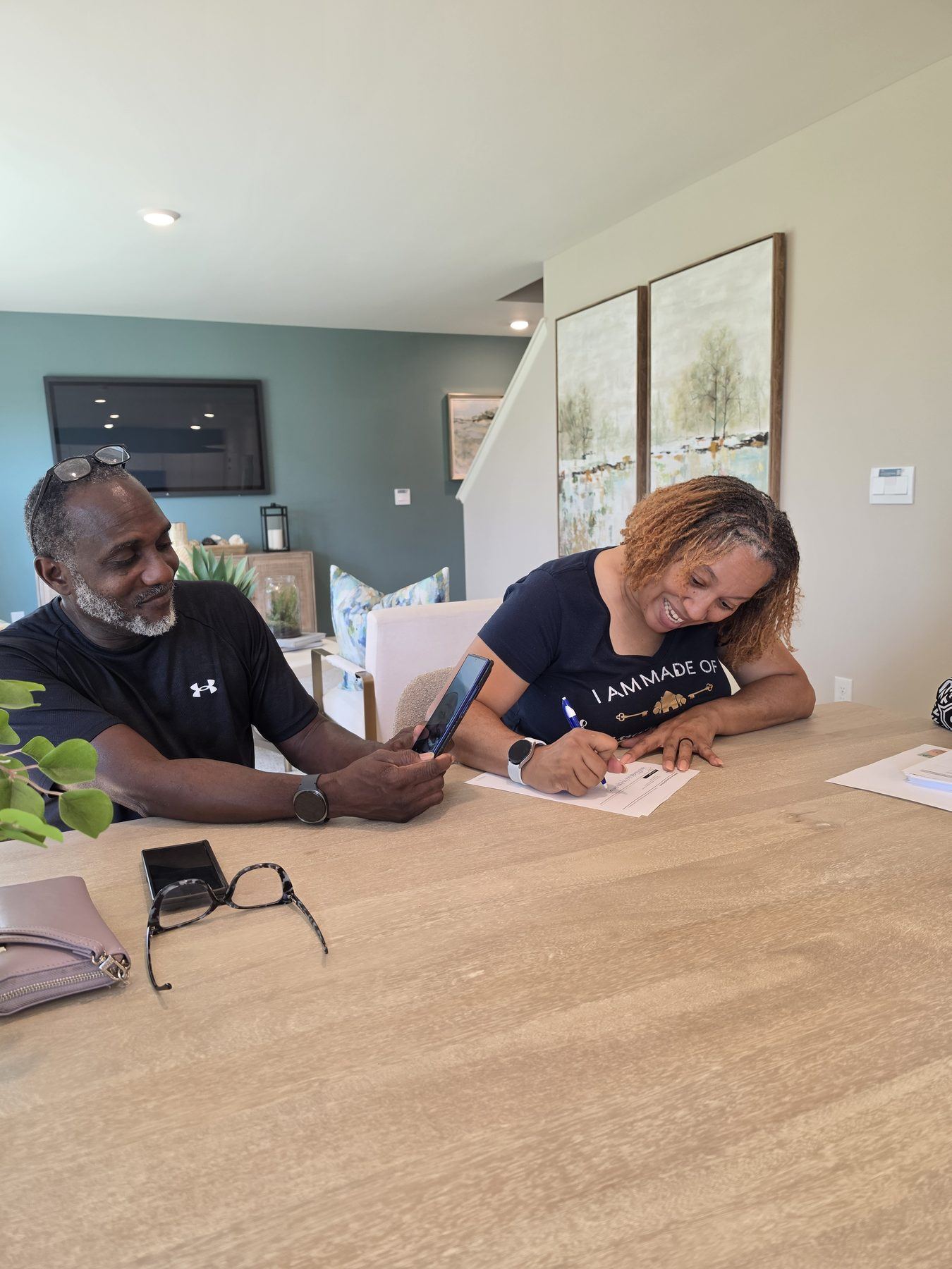Parents signing closing paperwork for their son's new construction home in Kentucky while he joins by video call