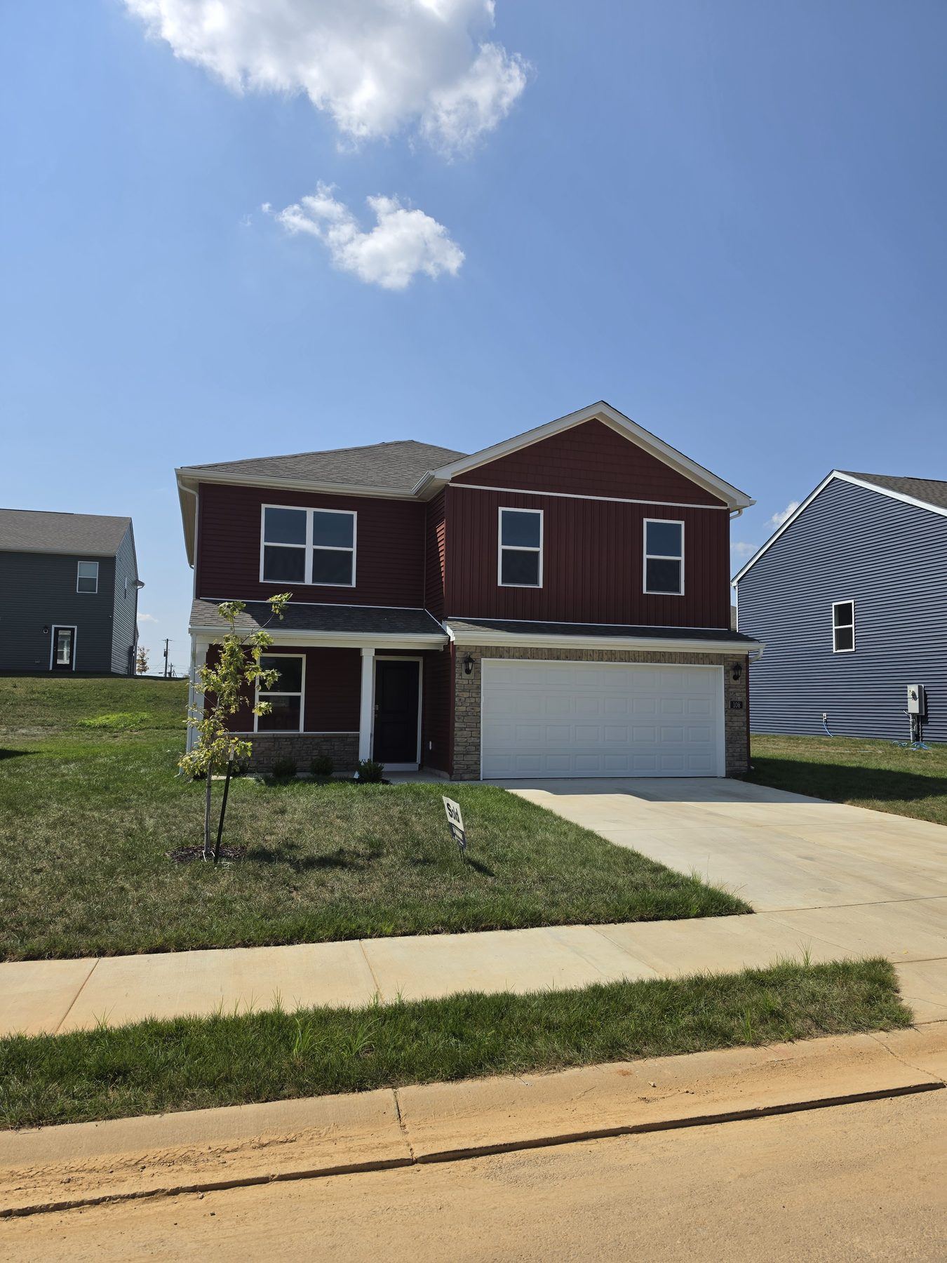 New construction two-story home in Kentucky with a Sold sign in the front yard